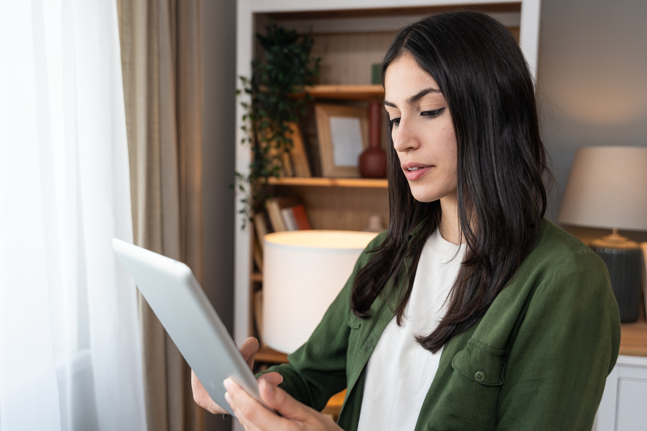 Homeowner reviewing cleaning service details on a tablet before booking.